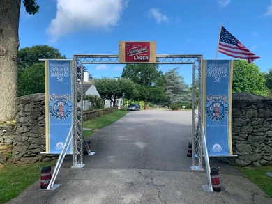 Entrance archway to the Summer Nights 5K with American flags.