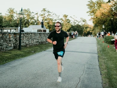 Male runner in sunglasses participating in the Summer Nights 5K.