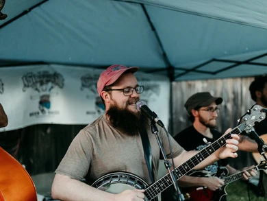 Musicians performing at Summer Nights 5K event under a tent.